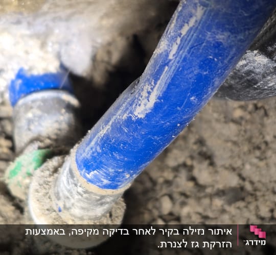 צינור כחול עם חיבורים על רקע אדמה